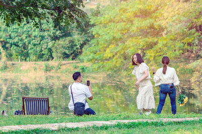 Rear view of people sitting on grassland