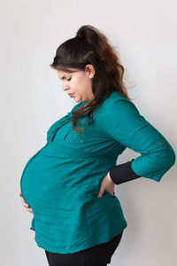 Side view of a young woman against white background