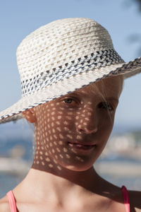 Close-up portrait of girl wearing hat