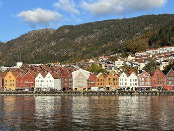 Colourful buildings by sea against mountain