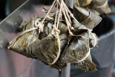 Food wrapped in banana leaves hanging for sale at market stall