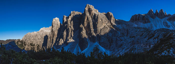 Low angle view of rocks against blue sky