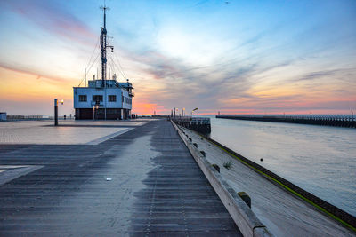 Pier amidst sea against sky during sunset