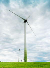 Low angle view of windmill on field against sky