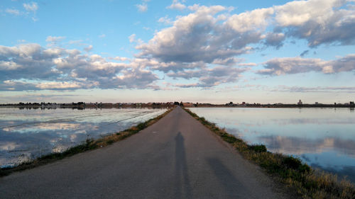 Panoramic view of road by landscape against sky