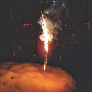 Close-up of lit candle in the dark