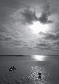 People swimming in sea against sky