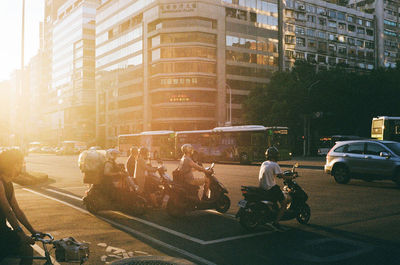 People on street against buildings in city