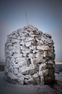 Stack of sculpture on beach against clear sky