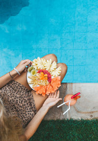 High angle view of woman holding pink flower in swimming pool