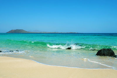 Scenic view of sea against clear blue sky