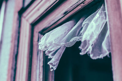 Low angle view of old curtain hanging from window