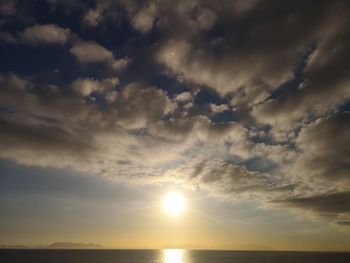 Scenic view of sea against dramatic sky during sunset