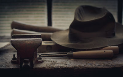 Close-up of abandoned hat and work tools on table