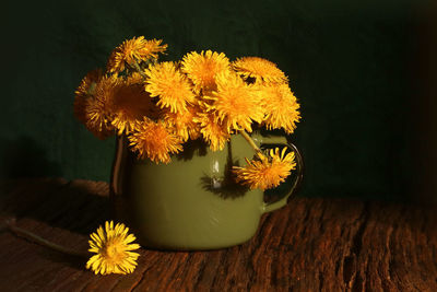Close-up of yellow flower pot on table