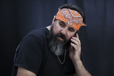 Close-up of bearded mature man talking on mobile phone