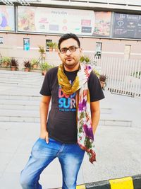 Portrait of young man standing against wall