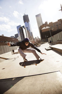 Man performing stunt with skateboard in park