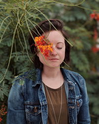 Portrait of young woman with red flower