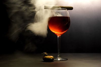 Close-up of wineglass with cigar on table