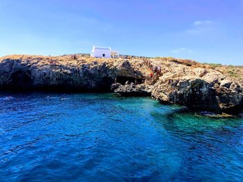 Sea by buildings against clear blue sky