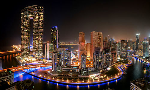 Illuminated modern buildings against sky at night