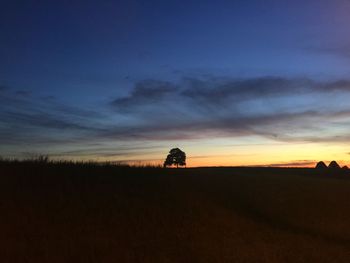 Silhouette field against sky during sunset