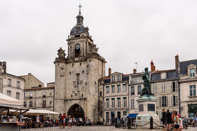 Group of people in front of buildings against sky