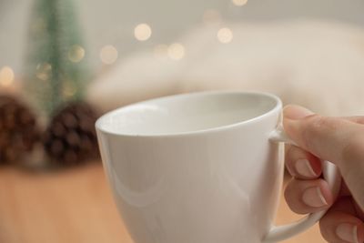 Close-up of hand holding coffee cup