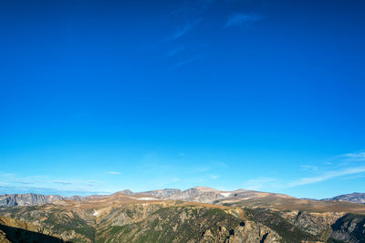 Scenic view of mountains against blue sky