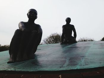 Men on rock against sky