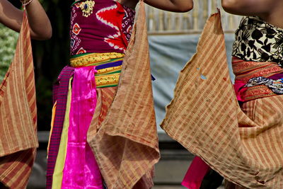 Midsection of woman holding multi colored umbrella