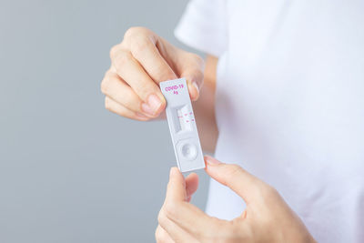 Midsection of person holding hands against white background