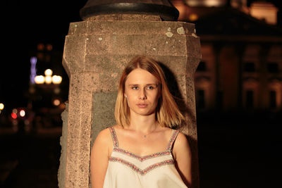 Portrait of young woman standing at night