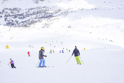 People skiing on snowcapped mountain during winter