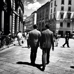 Rear view of businessmen walking on street in city