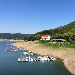 Boats in sea against clear sky