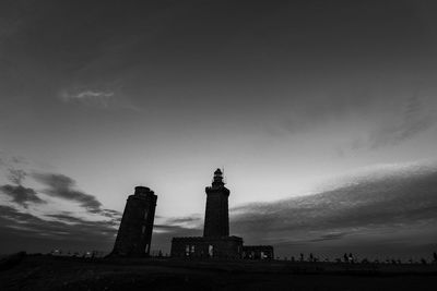 Low angle view of lighthouse against buildings