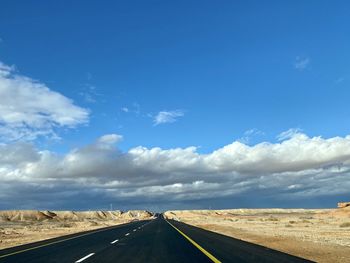 Empty road against cloudy sky