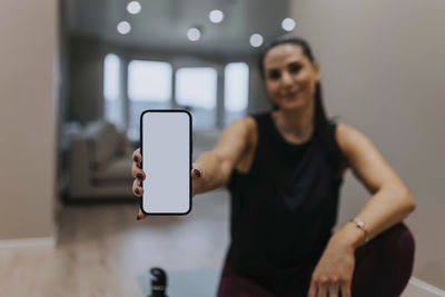 Woman's showing cell phone with workout app