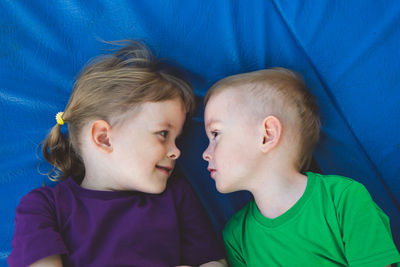 Two smiling children lie and look at each other. carefree childhood, freedom and tranquility. 