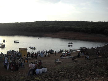 People at beach against sky