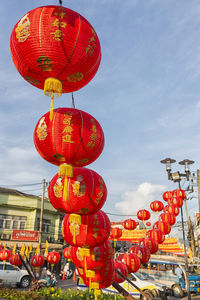 Low angle view of lanterns hanging against sky