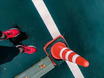 Low section of person with umbrella on road