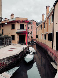 Canal amidst buildings in city against sky