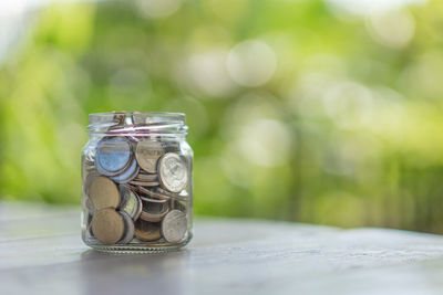 Close-up of coins in jar on table