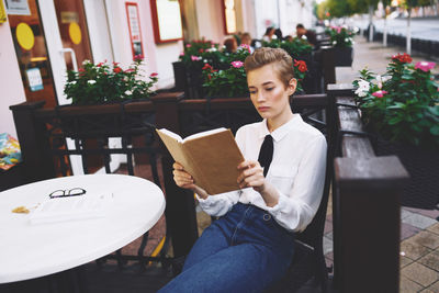 Young woman sitting on table at home