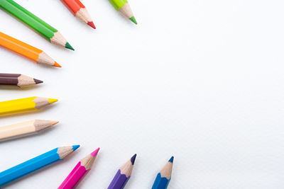 High angle view of colored pencils against white background
