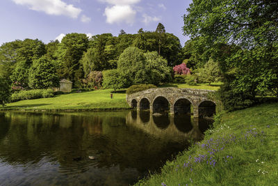 Arch bridge over river against sky