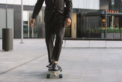 Low section of man riding skateboard